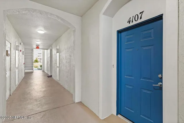 a view of kitchen with refrigerator and white cabinets