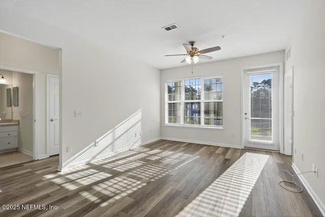 a view of a room with a window and wooden floor