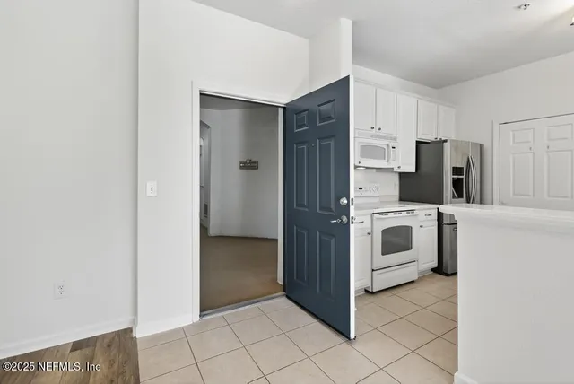a white refrigerator freezer and a stove sitting inside of a kitchen with stainless steel appliances