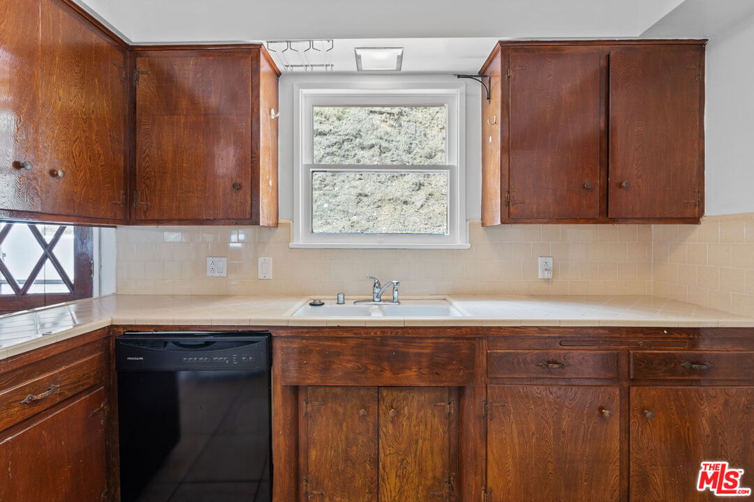 2485 Benedict Canyon Drive Beverly Hills, CA 90210 - Photo 12 of 33 a kitchen with granite countertop wooden cabinets a sink and dishwasher