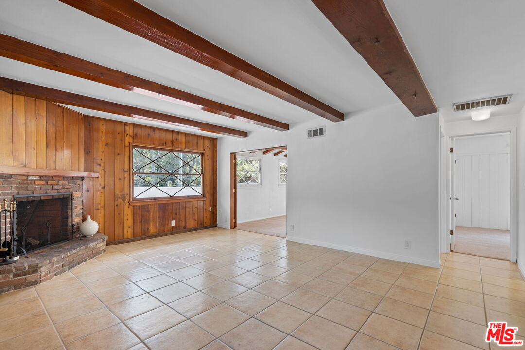 2485 Benedict Canyon Drive Beverly Hills, CA 90210 - Photo 15 of 33 a view of empty room with a fireplace