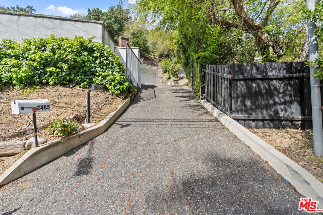 2485 Benedict Canyon Drive Beverly Hills, CA 90210 - Photo 31 of 33 a view of a pathway with a wrought fence