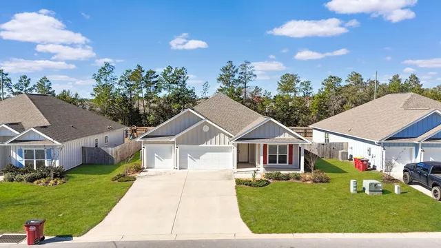 a front view of a house with a garden and trees