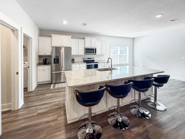 a kitchen with stainless steel appliances granite countertop a lot of counter top space and wooden floor
