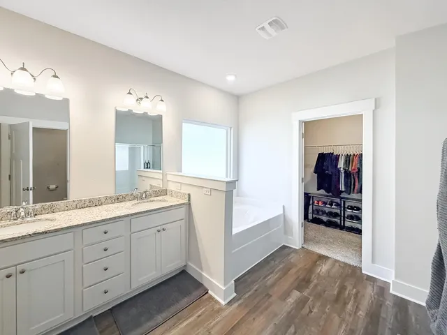 a view of walk in closet with clothes and shoes