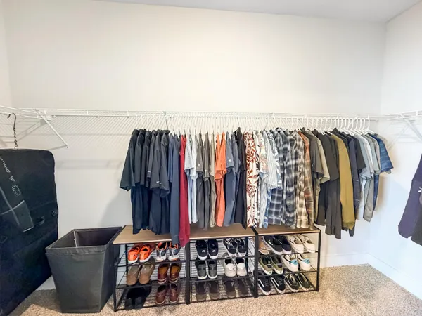a view of walk in closet with clothes