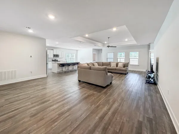 a living room with furniture and a wooden floor