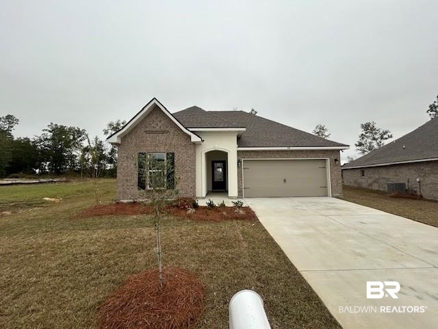 948 Ashville Circle Foley, AL 36535 - Photo 1 of 3 Ranch-style home with a front lawn, concrete driveway, brick siding, and an attached garage