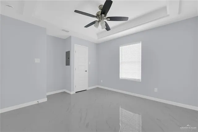 an empty room with a window and a fan