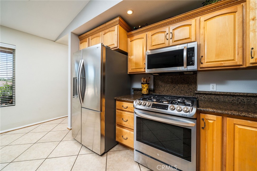 16639 Fox Glen Road Riverside, CA 92504 - Photo 9 of 153 a kitchen with stainless steel appliances granite countertop a stove a microwave and a refrigerator