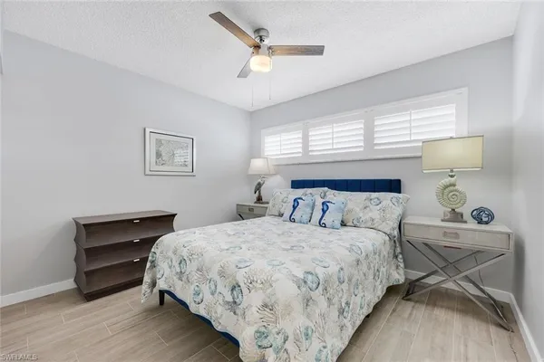 a bedroom with a bed and a ceiling fan