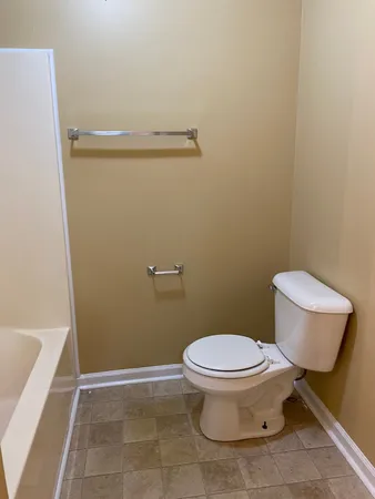 a white toilet sitting next to a bath tub