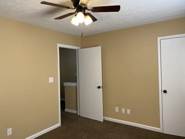 a view of a hallway with a chandelier fan