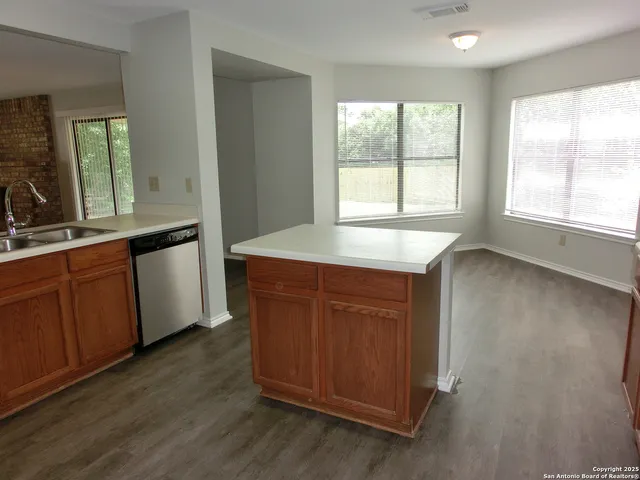 a kitchen with stainless steel appliances granite countertop wooden floors and sink