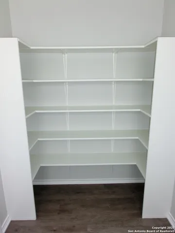 a view of walk in closet with empty racks