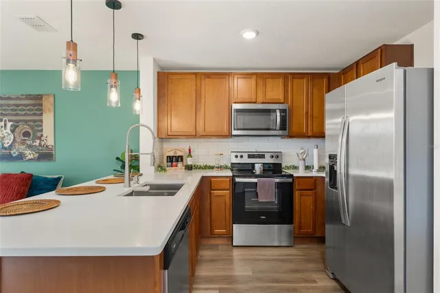 a kitchen with stainless steel appliances a refrigerator sink and microwave