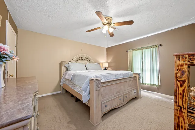 a spacious bedroom with a bed and a chandelier