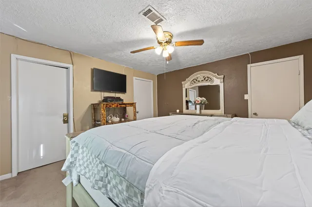 a bedroom with a large bed and a flat tv screen