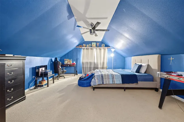 a spacious bedroom with a bed and a chandelier