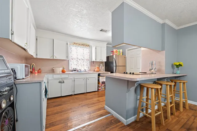 a kitchen with a sink cabinets and wooden floor