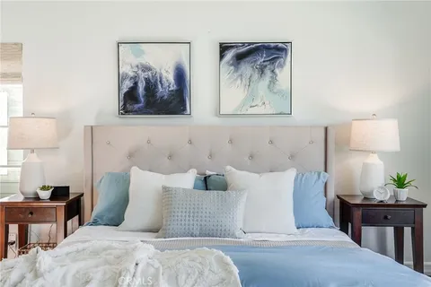 a bedroom with bed and painting on the wall