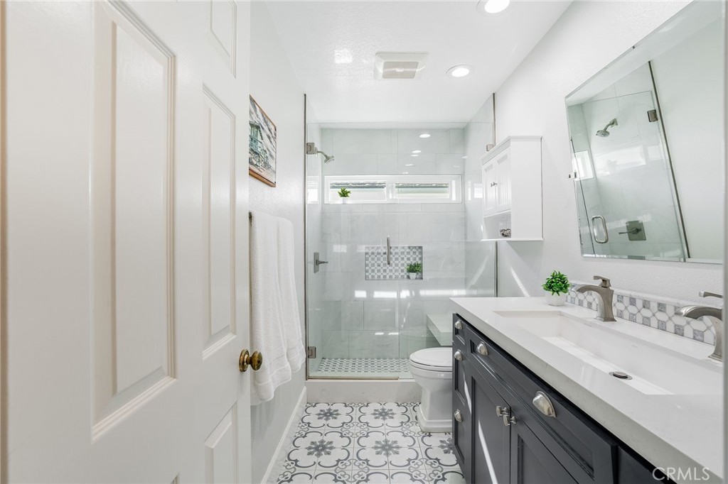 5 Lindall Street Laguna Niguel, CA 92677 - Photo 27 of 45 a bathroom with a granite countertop sink a toilet a shower and a mirror