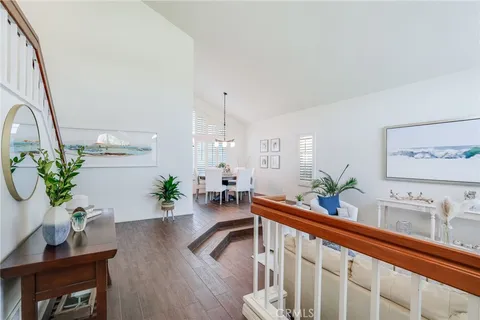 a living room with furniture a potted plant and open kitchen view