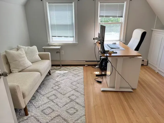 a living room with furniture a wooden floor and a large window