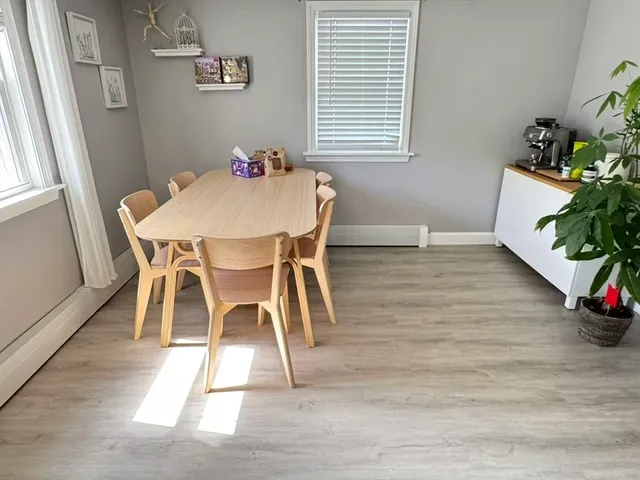 a view of a dining room with furniture and a potted plant