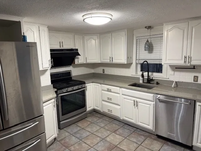 a kitchen with cabinets appliances and a sink