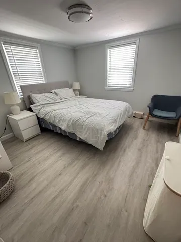 a bedroom with a bed couch and a window