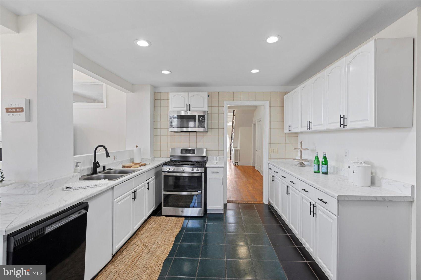 6602 Krone Drive Baltimore, MD 21207 - Photo 19 of 49 a kitchen with stainless steel appliances granite countertop a sink and cabinets