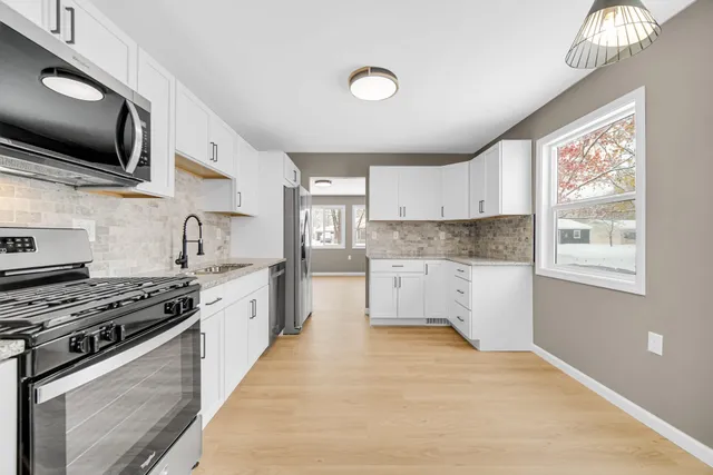 a kitchen with stainless steel appliances granite countertop a stove and a sink