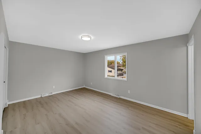 wooden floor in an empty room with a window