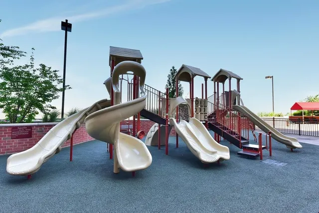 a front view of a building with a garden and plants
