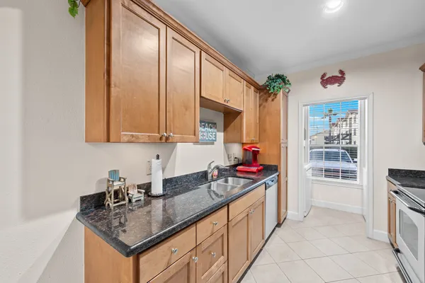 a kitchen with stainless steel appliances granite countertop a sink dishwasher and cabinets with wooden floor