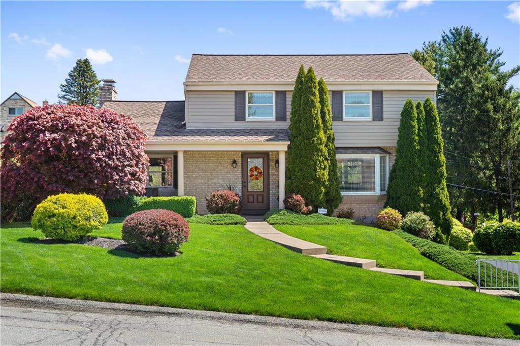 a front view of a house with a garden and plants