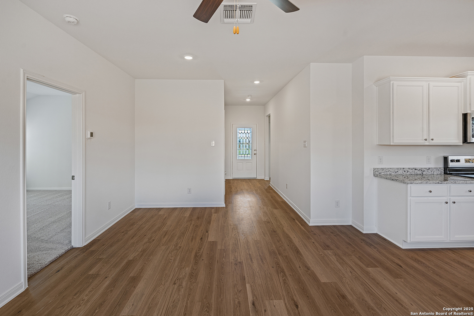 16148 Farmer Lytle, TX 78052 - Photo 3 of 33 a view of kitchen and empty room with wooden floor