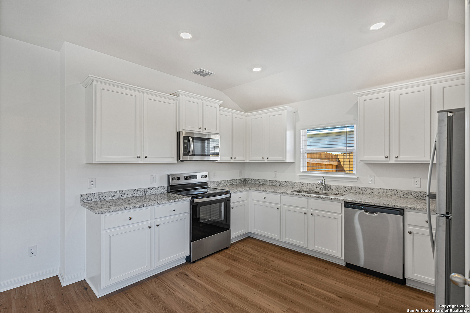 16148 Farmer Lytle, TX 78052 - Photo 10 of 33 a kitchen with stainless steel appliances granite countertop white cabinets granite counter tops and a hard wood floors