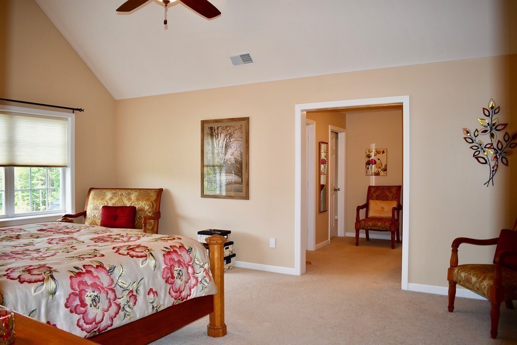 92 Robin Hill Road Groton, MA 01450 - Photo 20 of 30 a bedroom with a bed and a chandelier