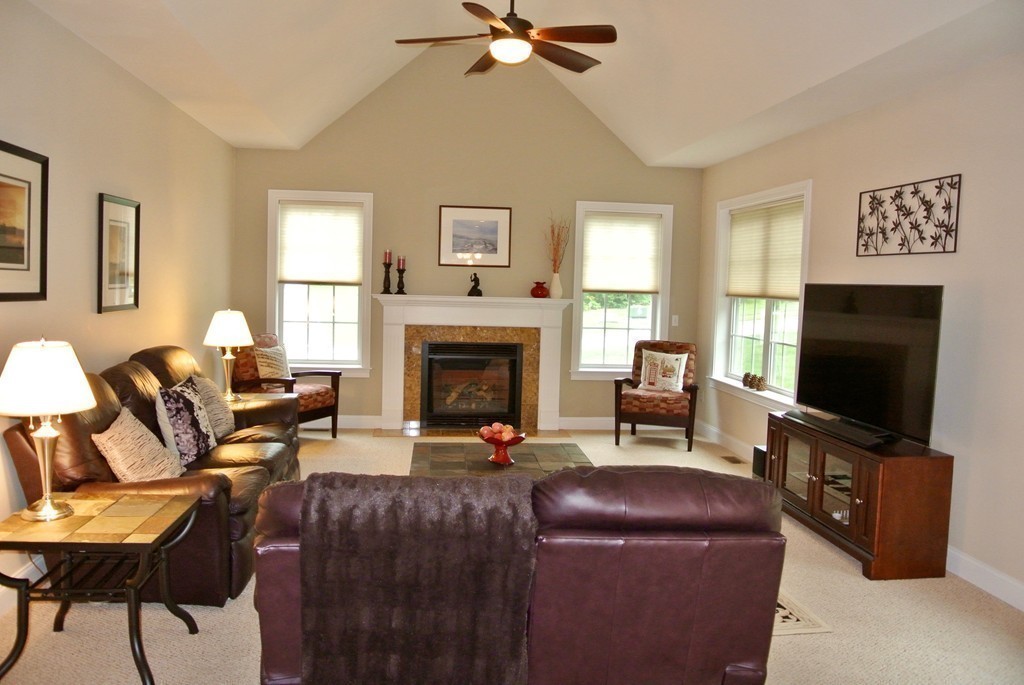 92 Robin Hill Road Groton, MA 01450 - Photo 9 of 30 a living room with furniture a flat screen tv and a fireplace