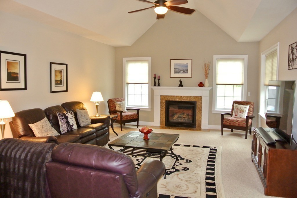 92 Robin Hill Road Groton, MA 01450 - Photo 10 of 30 a living room with furniture a fireplace and a flat screen tv