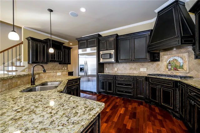 a kitchen with stainless steel appliances granite countertop a sink stove and refrigerator
