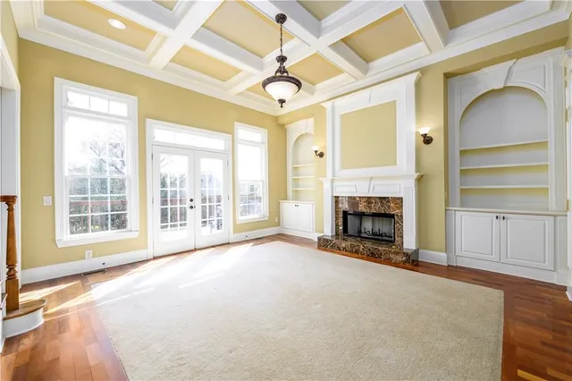 a view of a livingroom with a fireplace a ceiling fan and windows