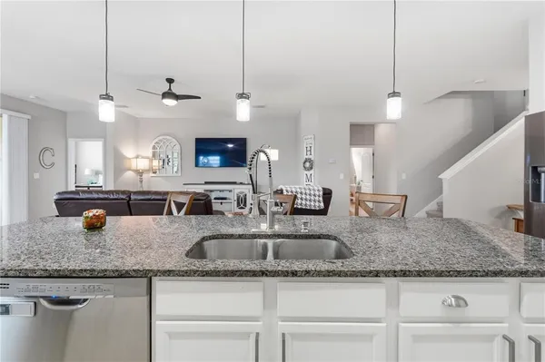 a kitchen with granite countertop a sink a counter top stainless steel appliances and cabinets