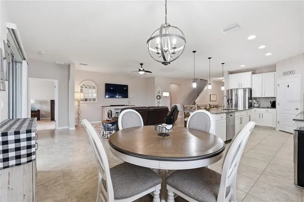 a dining room with wooden floor a chandelier a wooden table and chairs