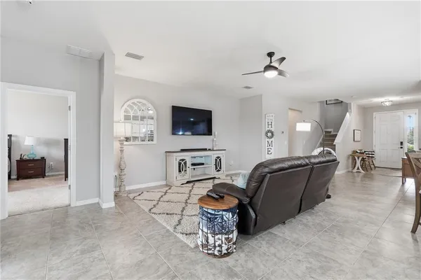 a living room with furniture a flat screen tv and kitchen view