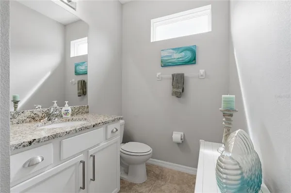 a bathroom with a granite countertop toilet sink and mirror