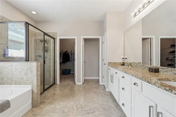 a bathroom with a granite countertop sink and a bathtub