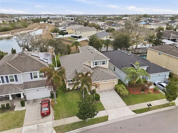 an aerial view of residential houses with outdoor space and parking